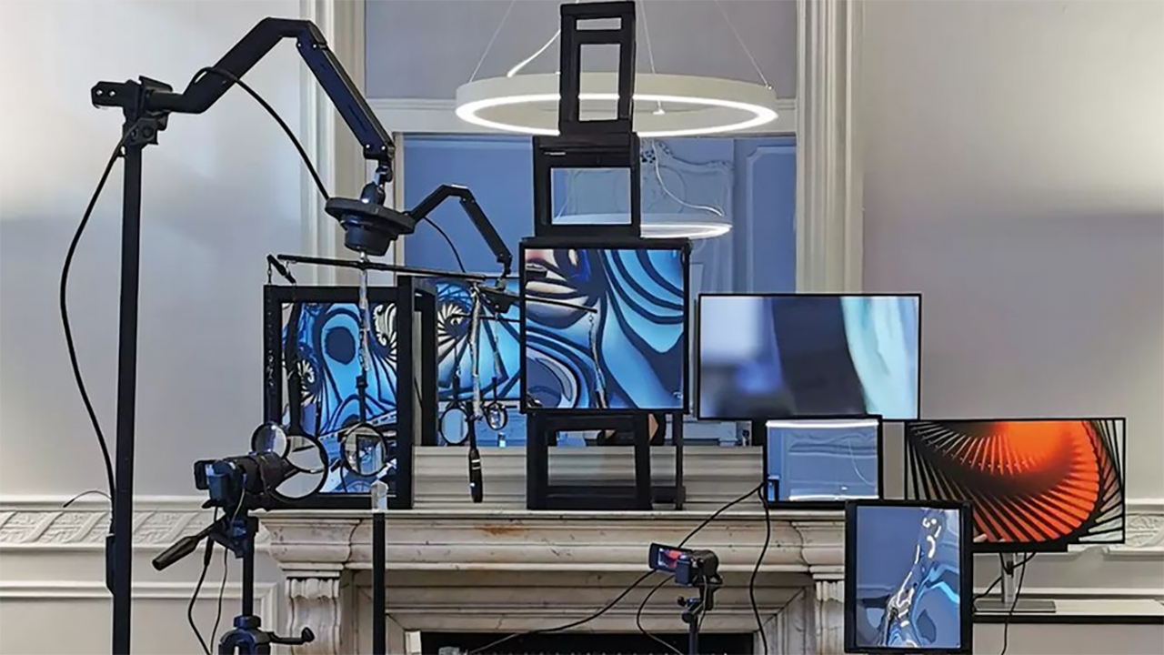 An art installation consisting of various monitors on which fluorescent colors in blue and black can be seen
