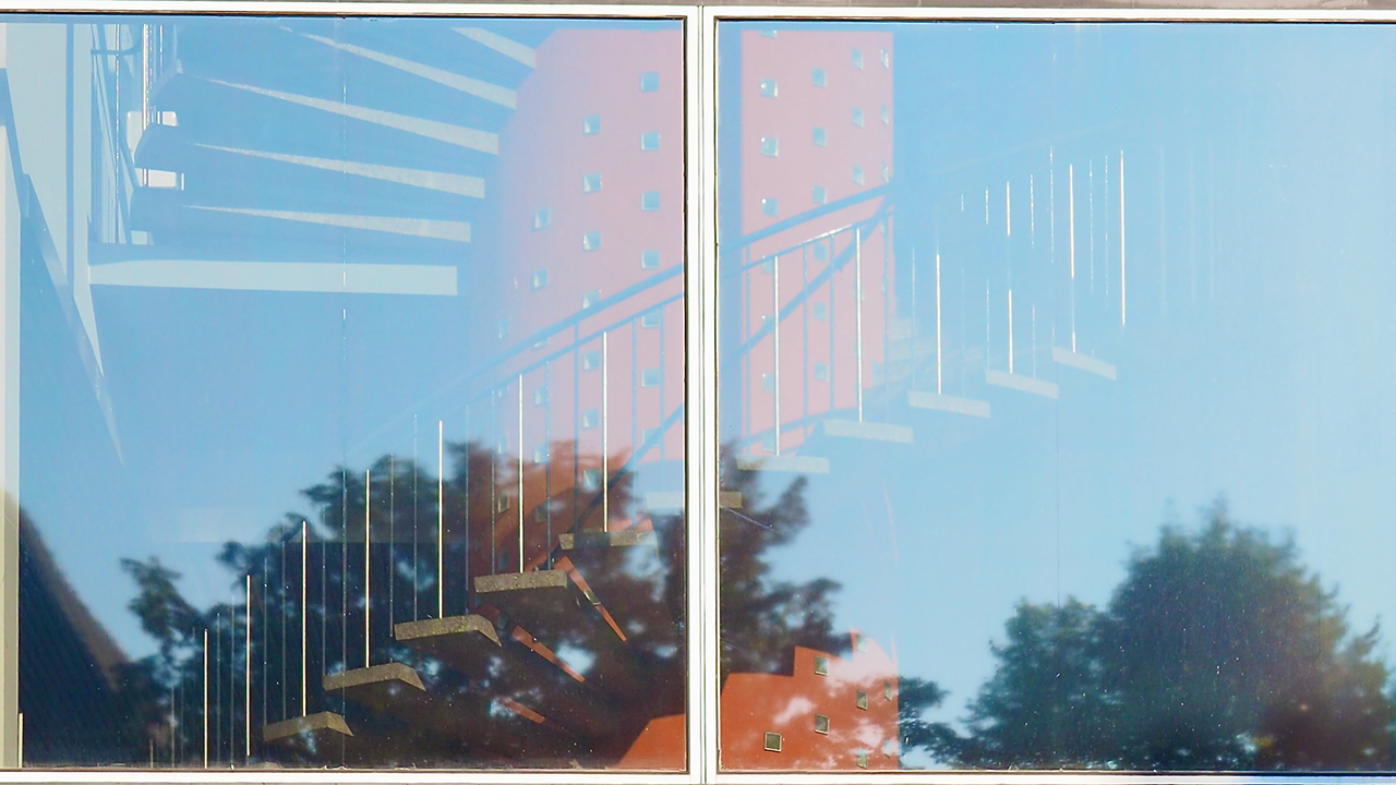 A spiral staircase photographed through a pane of glass.