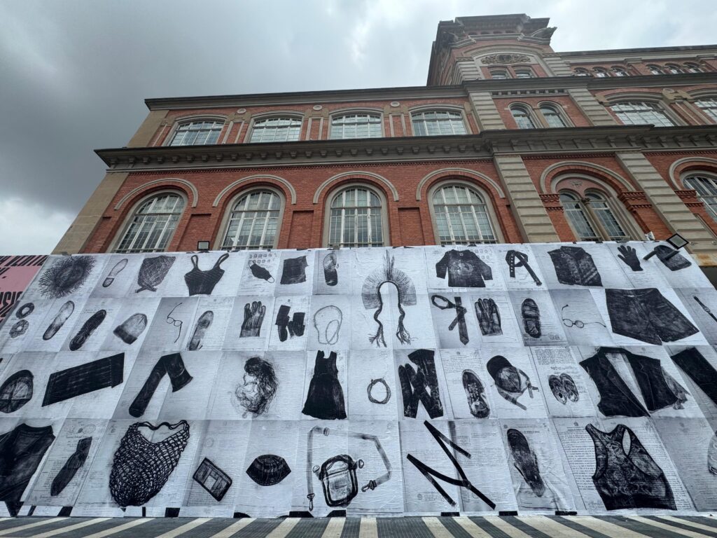 Black and white photos of various objects are mounted as a mural on a house wall.